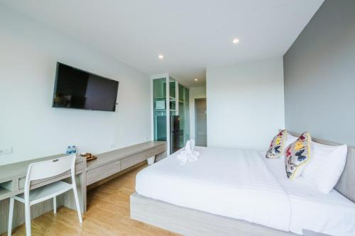 a bedroom with a bed and a desk and a tv at UR The Private Huahin in Hua Hin