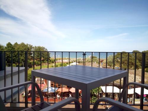 a table on a balcony with a view of the ocean at Baabe Villen Ensemble VE 19 Meerbl in Baabe
