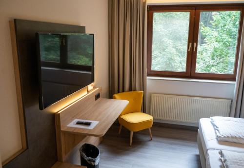 a hotel room with a flat screen tv and a bed at Hotel Haus Hohenstein in Witten