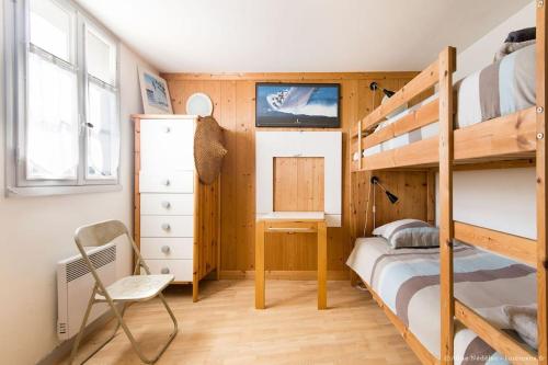 een slaapkamer met een stapelbed en een bureau bij Appartement de l'ilot. La fenêtre de Vauban. in Saint-Martin-de-Ré
