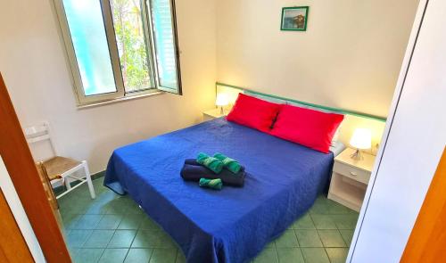 - une chambre avec un lit bleu et des oreillers rouges dans l'établissement Villa Ulimare Family Residence, à Vieste