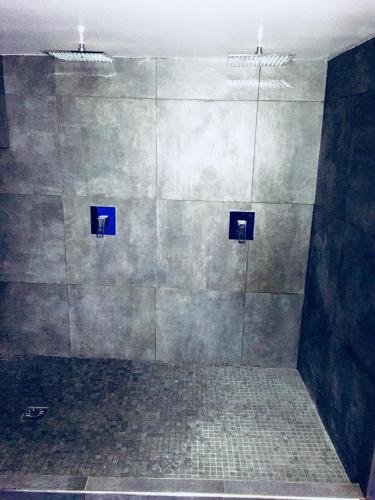 a bathroom with a shower with blue signs on the wall at Les Suites du Cours & Spa in Aix-en-Provence