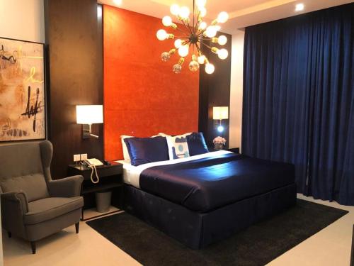 sypialnia z łóżkiem, krzesłem i żyrandolem w obiekcie Dana Hotel & Residences 2 w Rijadzie