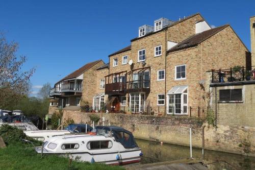 a group of boats docked in front of a building at Whitehouse Holiday Lettings - Luxury Serviced Properties in St Neots, Little Paxton and Great Paxton in Saint Neots