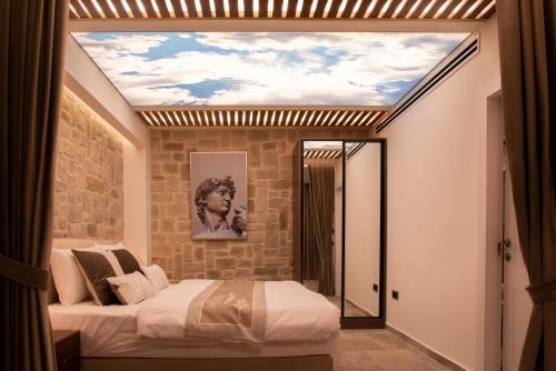 a bedroom with a ceiling with a mural of a woman at kadarim Boutique Suites-beachfront Zimmer in Haifa