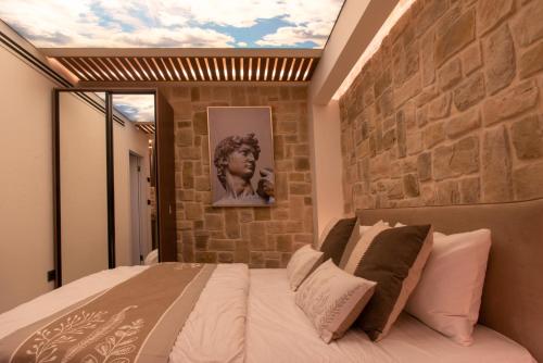 a bedroom with a stone wall and a bed at kadarim Boutique Suites-beachfront Zimmer in Haifa