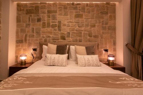 a bedroom with a large bed with a stone wall at kadarim Boutique Suites-beachfront Zimmer in Haifa