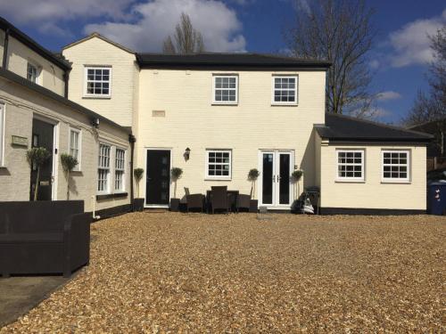 una gran casa blanca con un gran patio en Whitehouse Holiday Lettings - Luxury Serviced Properties in St Neots, Little Paxton and Great Paxton, en Saint Neots