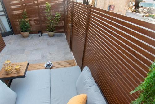 a patio with a wooden fence and a table at kadarim Boutique Suites-beachfront Zimmer in Haifa