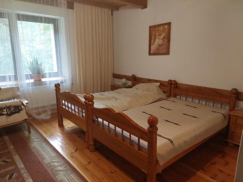 a bedroom with a wooden bed and a window at Leśniczówka Hamernia 