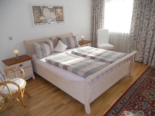 1 dormitorio con 1 cama blanca grande y 1 silla en Ferienwohnung Edmeier, en Bernau am Chiemsee