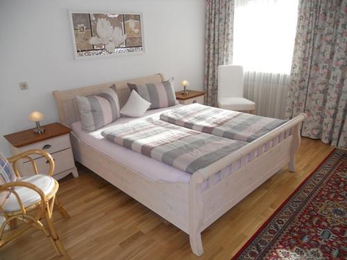 a bedroom with a large white bed and a chair at Ferienwohnung Edmeier in Bernau am Chiemsee