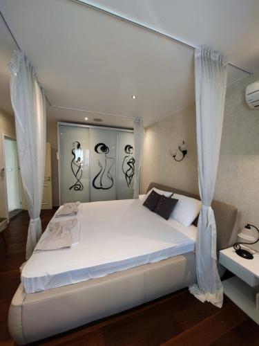 een slaapkamer met een groot wit bed en gordijnen bij Ap-Art Sofia in Sofia
