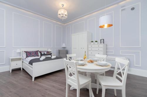 a bedroom with a bed and a table and chairs at Perła Starego Miasta Kamienica Czapskich by Renters in Krakow