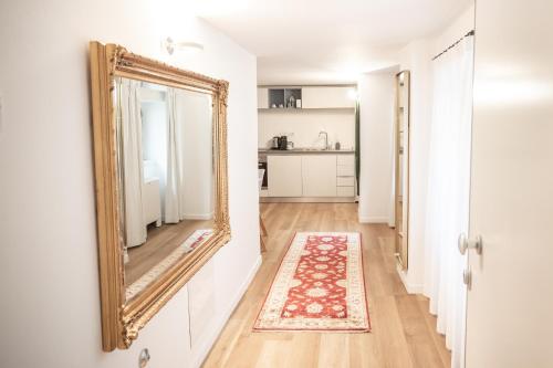 a mirror on a wall next to a hallway with a rug at Grand Hotel Duchi d'Aosta Apartments in Trieste