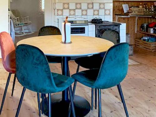 una mesa con 4 sillas y una vela en la parte superior en 5 person holiday home in HAGFORS en Hagfors
