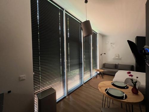 a living room with a table and a large window at Amsterdam Beach House in Zandvoort