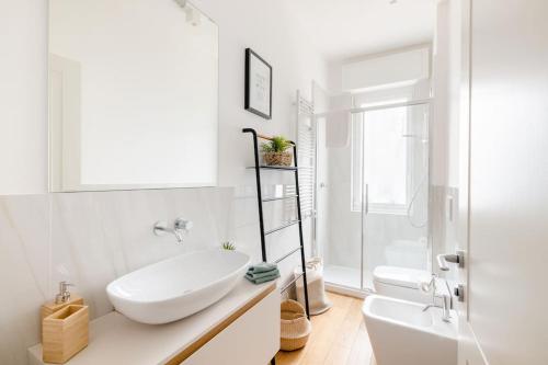 Baño blanco con bañera y lavamanos en Ripa Apartments Milano - Pastorelli en Milán
