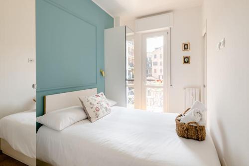 a bedroom with a white bed with a basket on it at Ripa Apartments Milano - Pastorelli in Milan