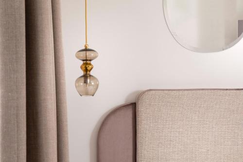 aendant light hanging from a wall next to a mirror at Hôtel Eiffel Saint Charles in Paris