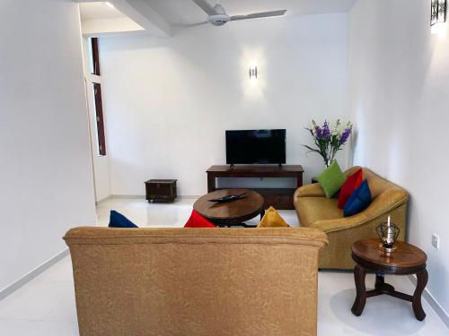 sala de estar con sofá y mesa en Welaratne Apartment, en Nugegoda