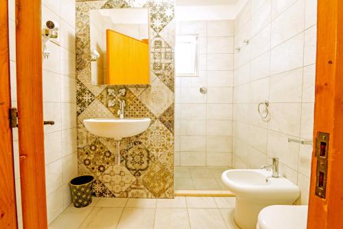 La salle de bains est pourvue d'un lavabo et de toilettes. dans l'établissement Villa Ulimare Family Residence, à Vieste