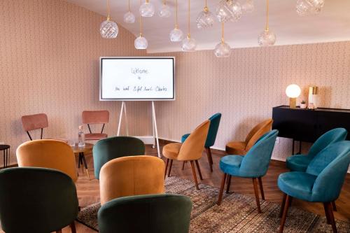 a waiting room with chairs and a projection screen at Hôtel Eiffel Saint Charles in Paris
