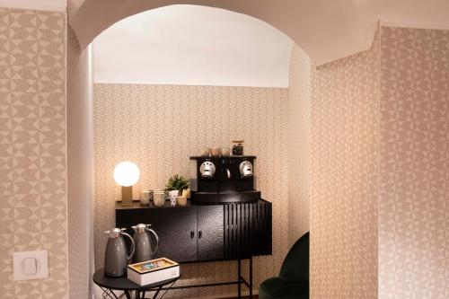 a room with a table with a lamp on a wall at Hôtel Eiffel Saint Charles in Paris