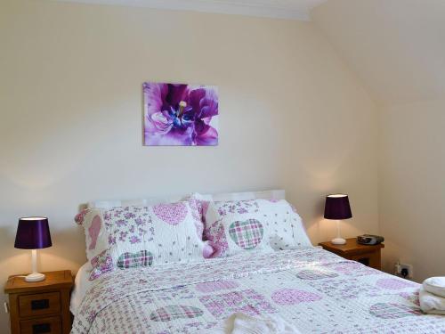 a bedroom with a bed with a purple flower painting on the wall at Riverside in Newton Stewart