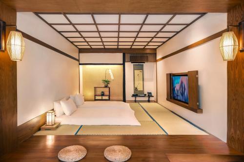 a bedroom with a large bed and a tv at Onsen at Moncham in Mae Rim
