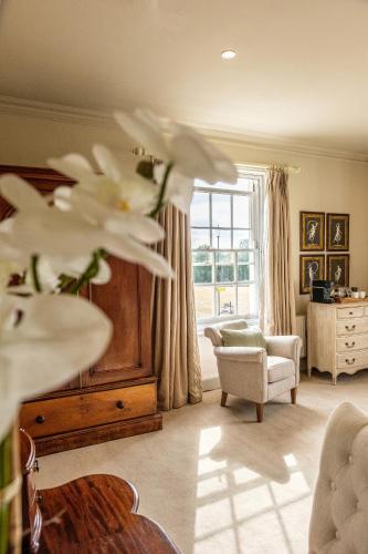 a living room with a large window and a chair at The Black Lion, Long Melford in Long Melford