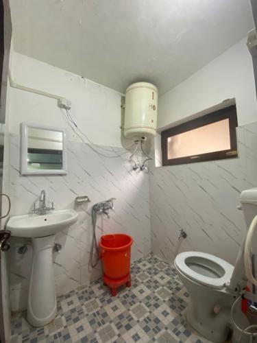 a bathroom with a toilet and a sink at Hotel Border View in Kargil