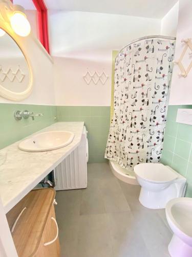 a bathroom with a sink and a toilet and a shower at Appartamenti Marinetta in Marina di Bibbona