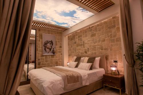 a bedroom with a large bed and a stone wall at kadarim Boutique Suites-beachfront Zimmer in Haifa