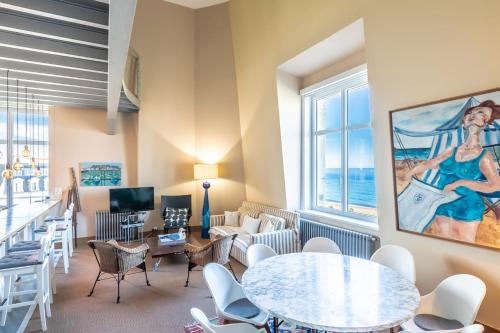 un salon avec une table et des chaises dans l'établissement SUN KEYWEEK Duplex Breathtaking view of the Ocean and Palace Gardens, à Biarritz