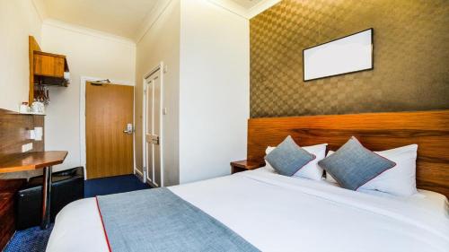 ロンドンにあるThe Park Hotelのベッドとテーブルが備わるホテルルームです。