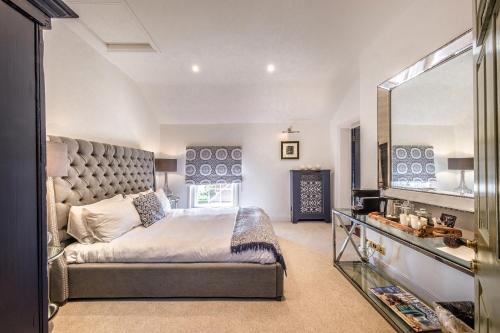 a bedroom with a large bed and a large mirror at The Black Lion, Long Melford in Long Melford