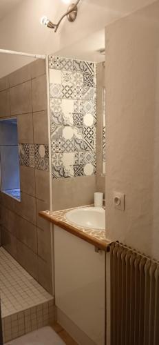 une salle de bain avec un lavabo et une douche dans l'établissement Gîte 