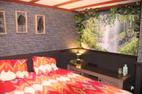een slaapkamer met een bed en een groot schilderij aan de muur bij Veluwe Park Reewold Chalet Vision in Putten