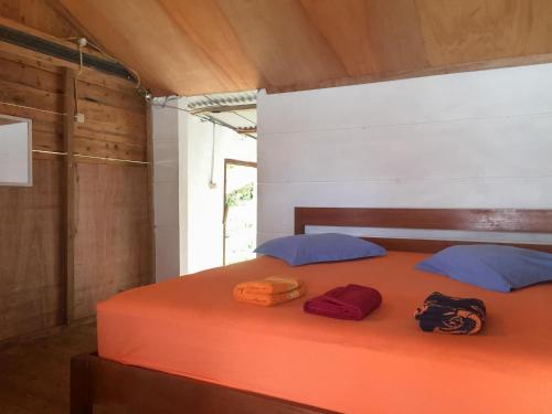 Una cama en una habitación con dos bolsas. en Olala Bungalows And Restaurant Mitra RedDoorz en Banda Aceh