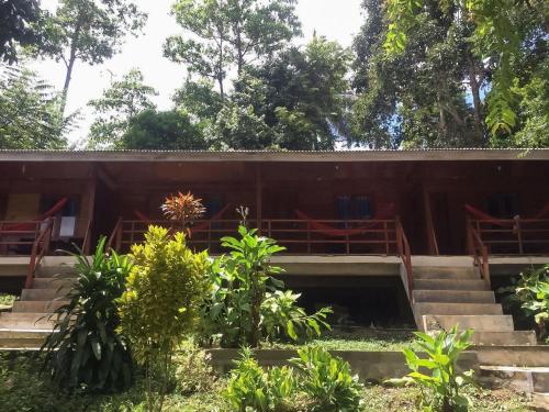 a building with stairs and trees in the background at Olala Bungalows And Restaurant Mitra RedDoorz in Banda Aceh