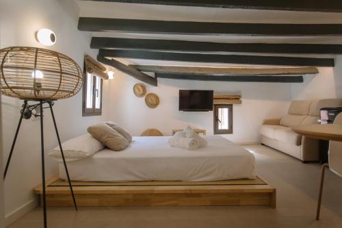 1 dormitorio con 1 cama, 1 lámpara y 1 sofá en Mayor 36 by Seaward Suites, en Villajoyosa