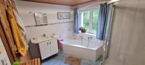 bagno con vasca e lavandino di Ferienhaus Waldhäus'l a Bärenstein