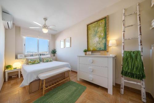 a bedroom with a bed and a dresser and a window at SPECTACULAR SEA VIEW Fuengirola in Fuengirola