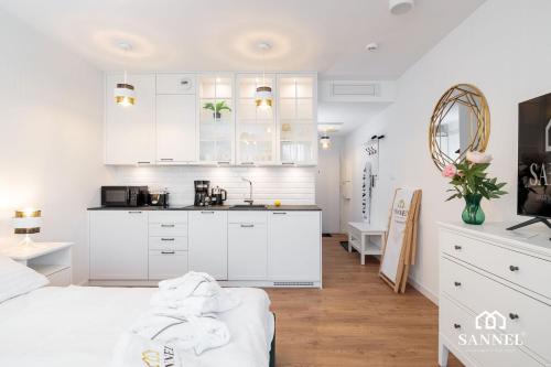 una cucina bianca con mobili bianchi e un lavello di Apartament Golden Mirror z basenami, strefą saun,jacuzzi W CENIE!- Pinea Apartments Pobierowo-SANNEL Apartments for rent a Pobierowo