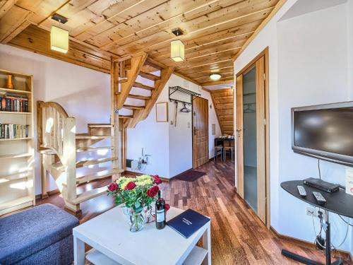 salon z kanapą i stołem z kwiatami w obiekcie VisitZakopane - Tetmajera Apartment w Zakopanem
