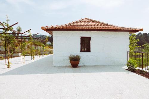 a small white building with a tile roof at Oliveiras Village — Agroturismo in Amarante