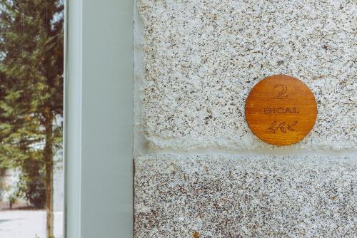 a wooden sign on the side of a building at Oliveiras Village — Agroturismo in Amarante