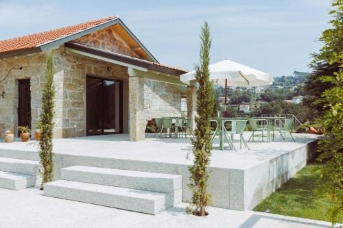a patio with stairs and a table and chairs at Oliveiras Village — Agroturismo in Amarante
