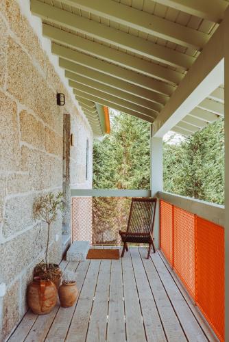a wooden porch with a bench and a brick wall at Oliveiras Village — Agroturismo in Amarante
